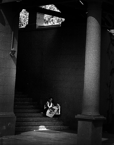 Quiet Times #49 by Jeremy Chin - Man Reading Newspaper on Steps in Malacca, Malaysia